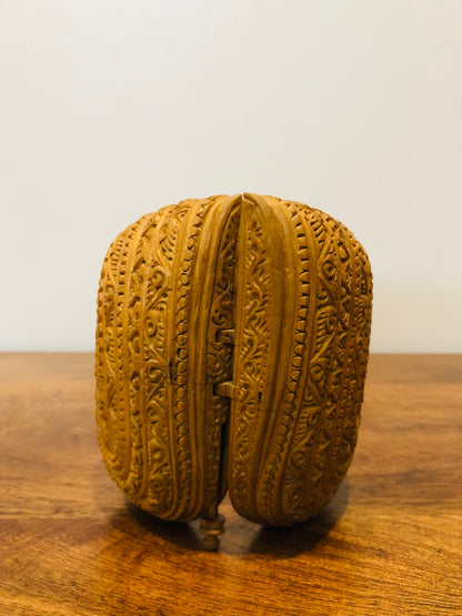 Sandalwood carved god inside shell