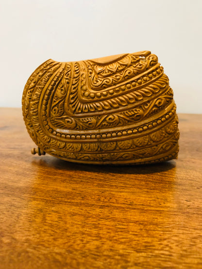 Sandalwood carved god inside shell